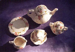 Tea set with tea pot, cups, and saucers